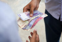 Two man doing transaction with indonesian rupiah in hand