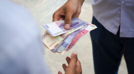Two man doing transaction with indonesian rupiah in hand