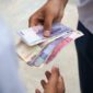 Two man doing transaction with indonesian rupiah in hand